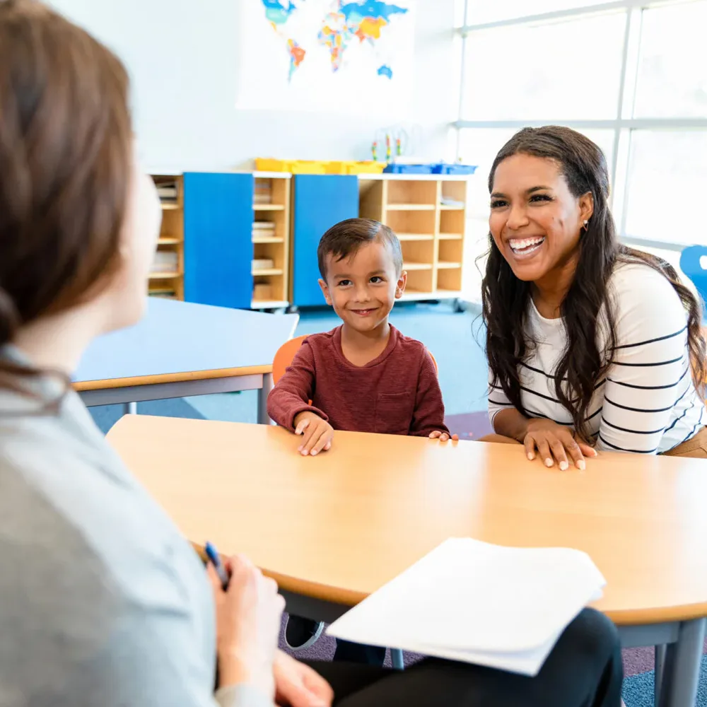 A child and an adult at a table in a Peace of Mind daycare