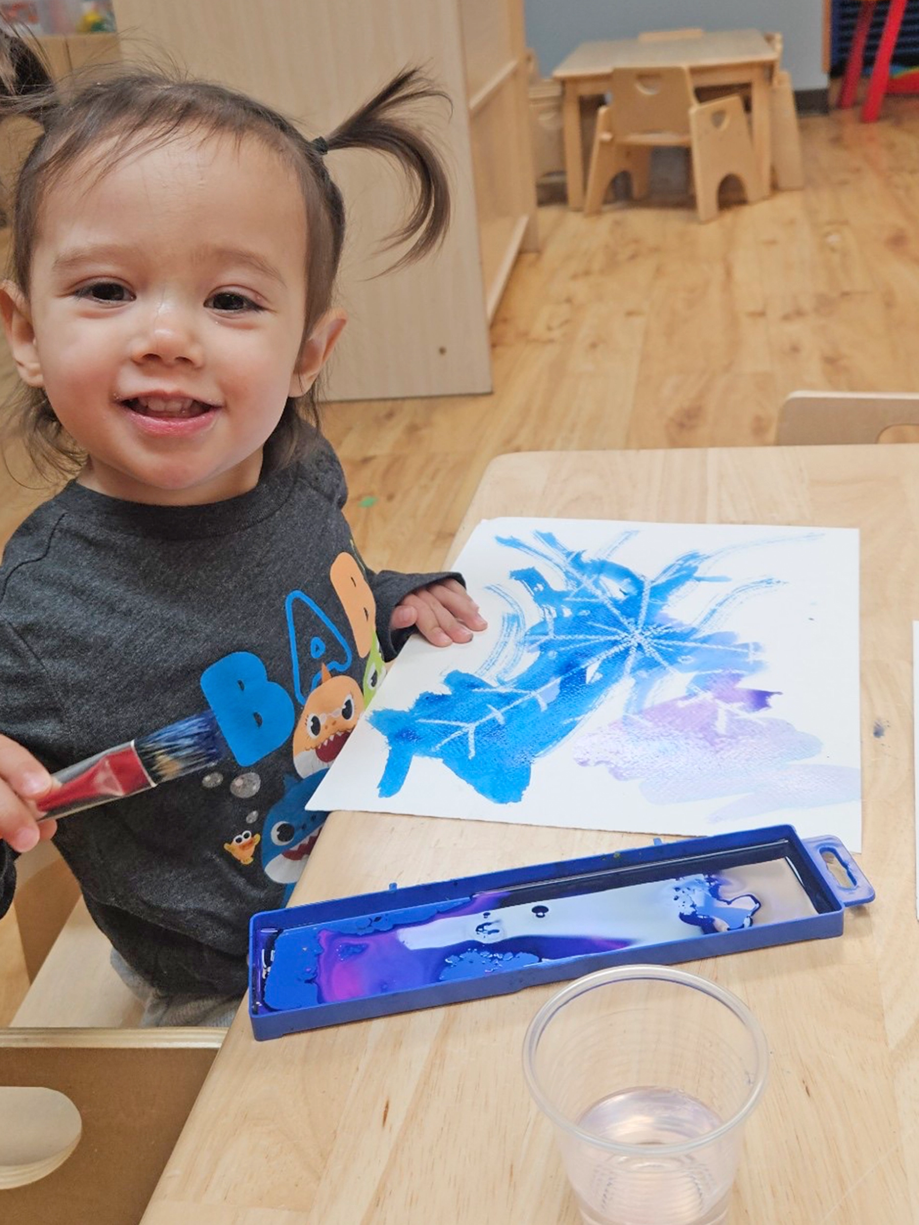 Child coloring with blue crayon at a Peace of Mind daycare.