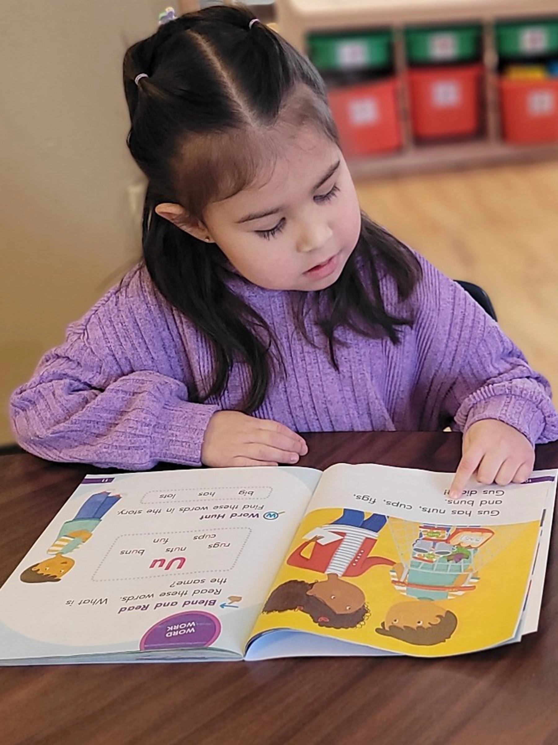 A child in purple reading a book at Peace of Mind daycare.